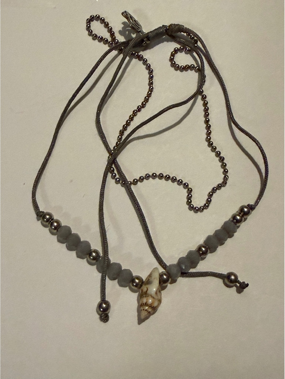 Gray bead cord bracelet with shell charm